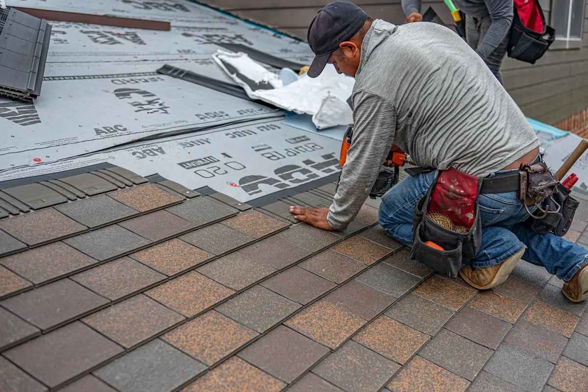 Roofer installing new roofing felt during a repair