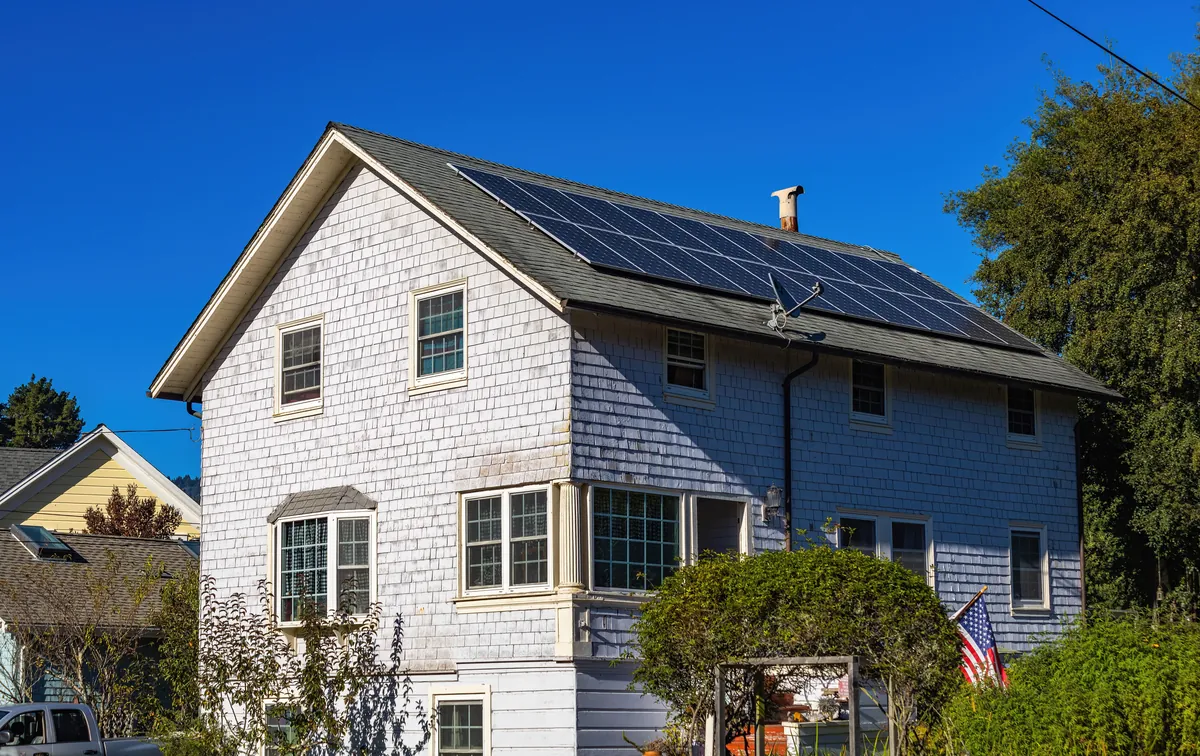 Modern house with solar panels fitted on the roof under a clear sky